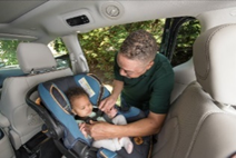 image-4 Infant being buckled in rear facing car seat by dad