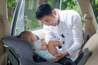 image Dad buckling baby in car seat